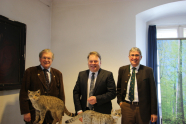Helmut Brunner mit Prof. Weiger (BN) und Reinhard Neft (BaySF) hinter einer ausgestopften Wildkatze.