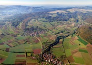 ein Luftbild einer Agrarlandschaft mit vielen unterschiedlich gefärbten Feldern.