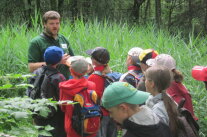 Förster mit einer Gruppe Kinder im Wald