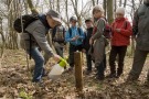 Besprühen eines Lockstocks mit Baldrianlösung, von Kindern umringt.