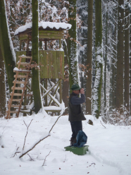 Jäger im Winter vor Hochsitz